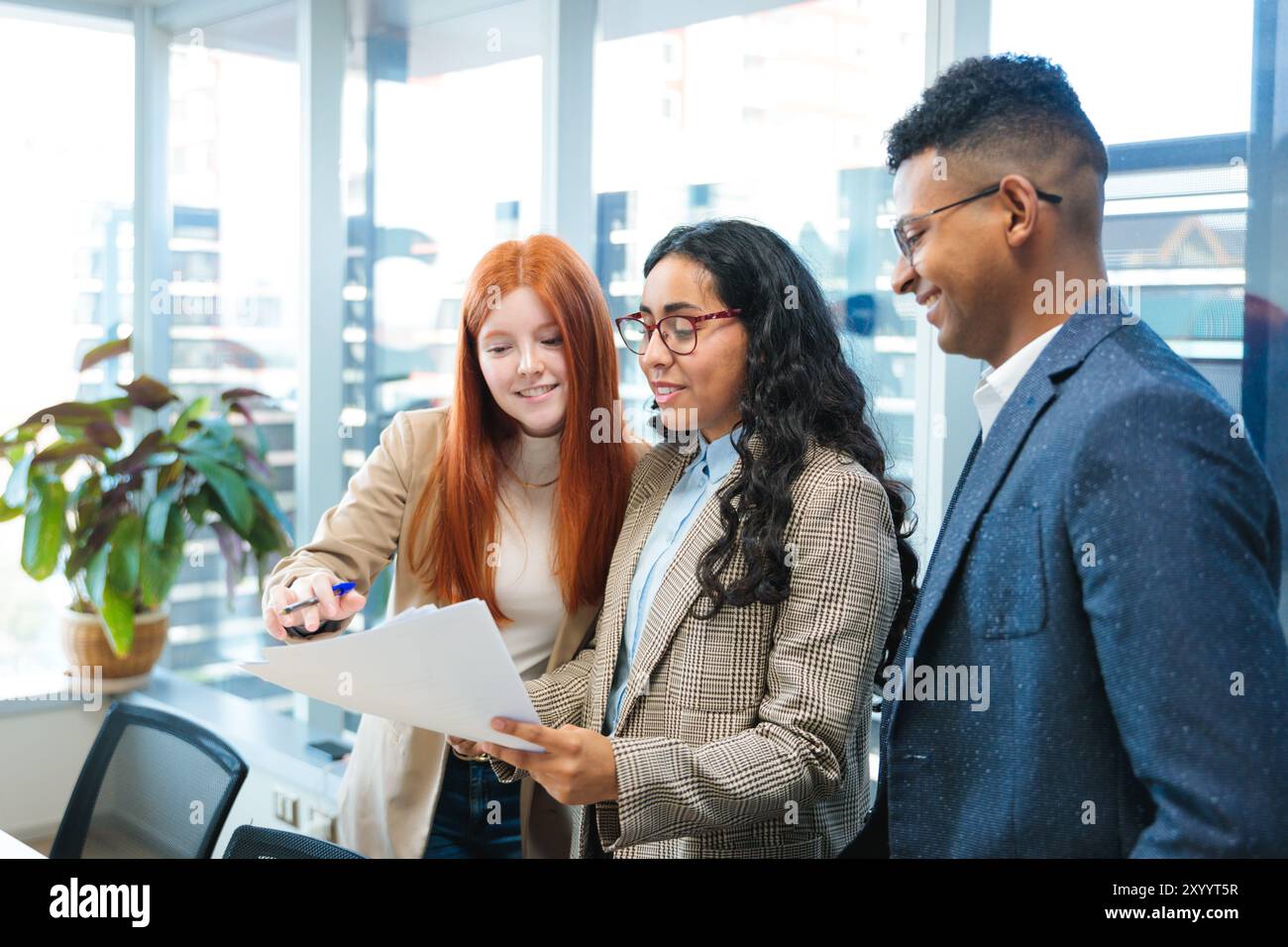 Kooperationsprojekt im hellen Co-Working-Raum unter der Leitung junger lateinischer Geschäftsleute. Teamarbeit und Bedeutung der Gemeinschaft Stockfoto