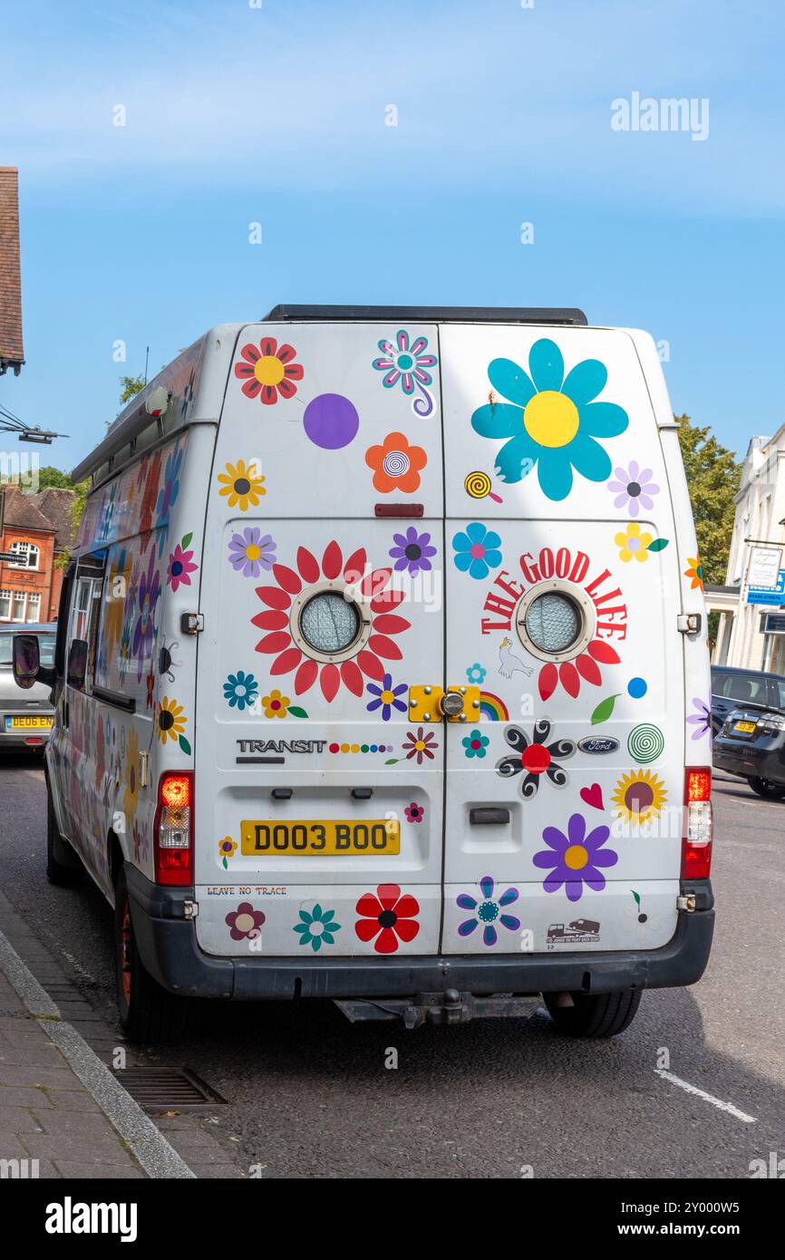 Farbenfroher Transportbus mit Blumen, Blumengemälde, mit Worten das gute Leben, die Kraft der Blumen Stockfoto