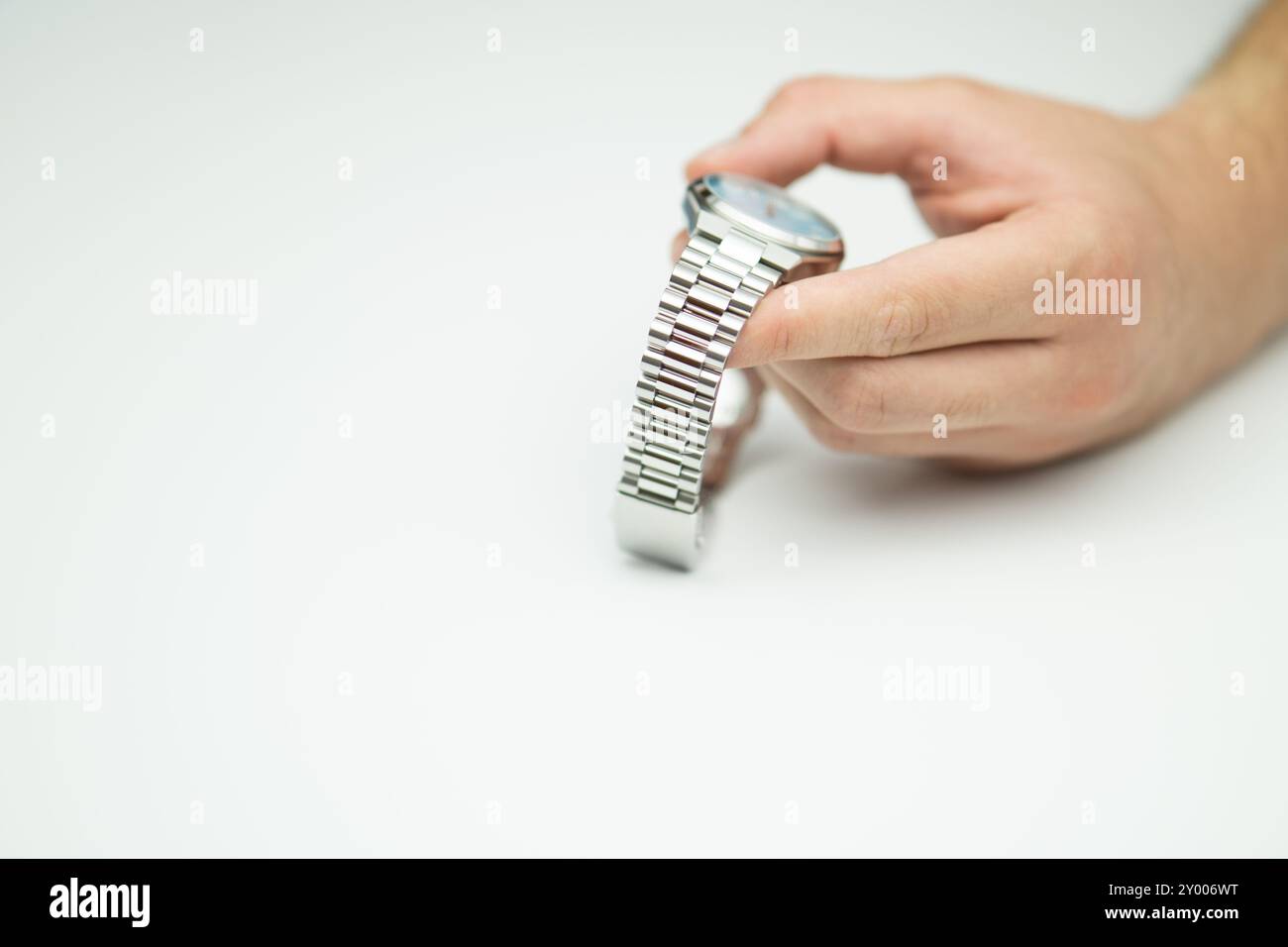 Männliche Hand, die moderne luxuriöse silberne tiffany-blaue Uhr auf weißem Hintergrund hält Stockfoto