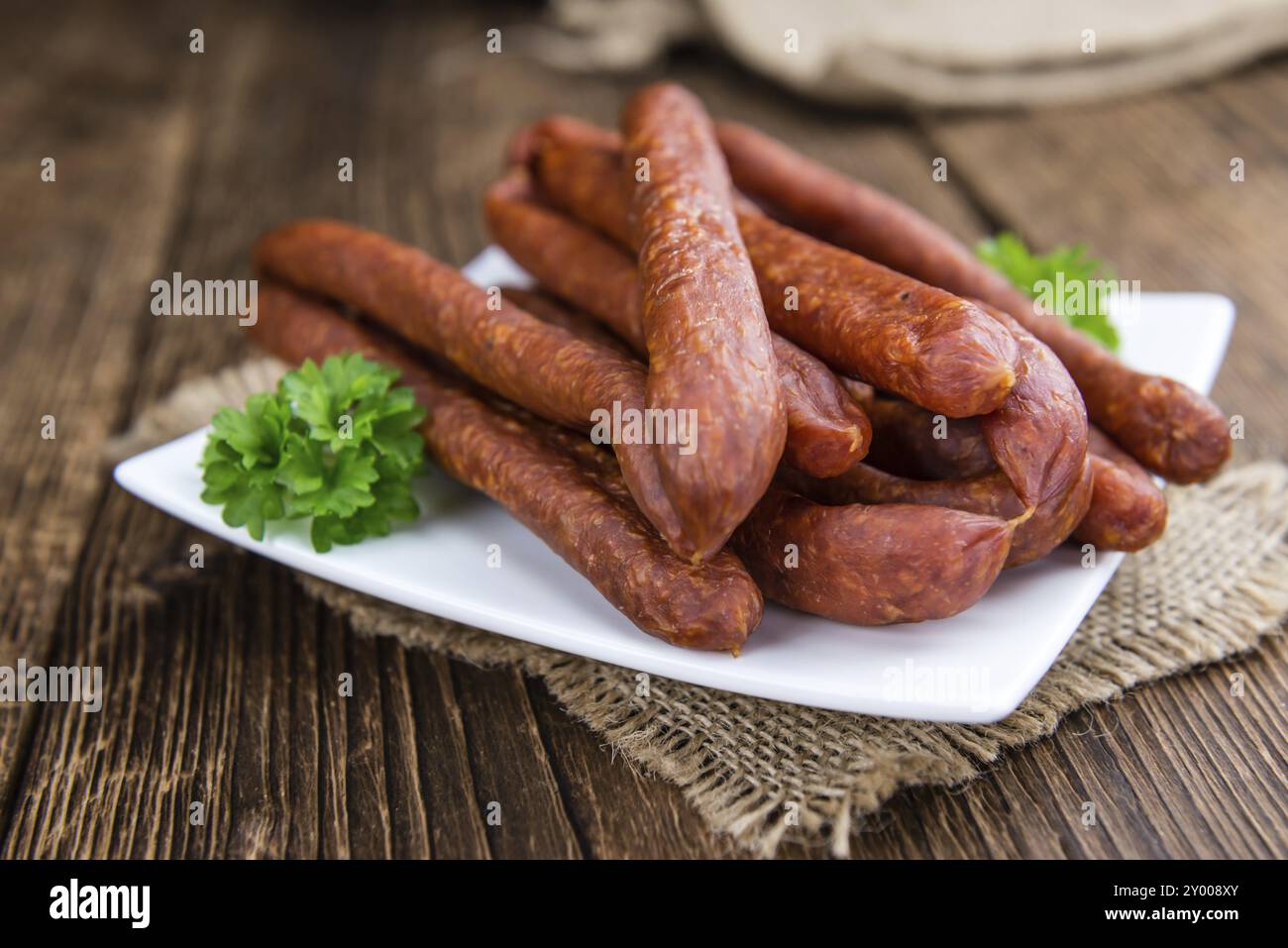 Deutsche Mettwurst (Chili aromatisiert) als Nahaufnahme (Tiefenschärfe) auf hölzernen Hintergrund Stockfoto