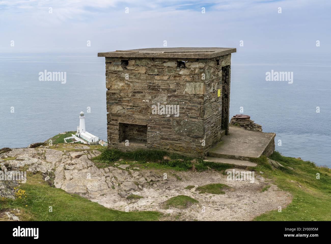 In der Nähe von Holyhead, Anglesey, Gwynedd, Wales, Großbritannien 8. Juni 2018: alte Küstenwache Hütte mit South Stack Lighthouse im Hintergrund Stockfoto