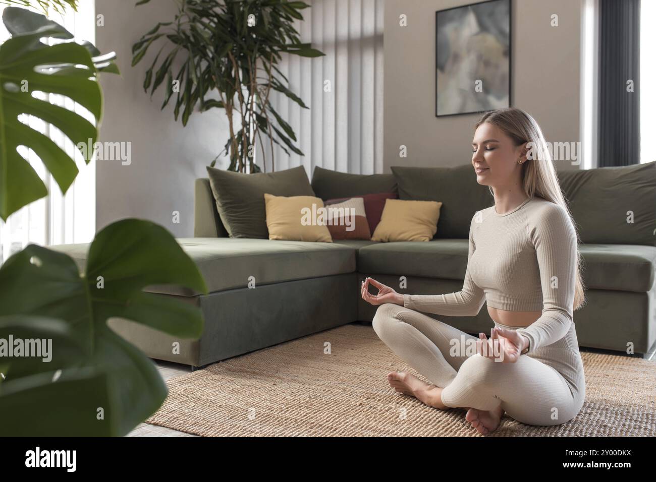 Gesundes Lifestyle-Konzept mit Mädchen tun Yoga-Übungen zu Hause Mit grünem Loft-Innenraum Stockfoto