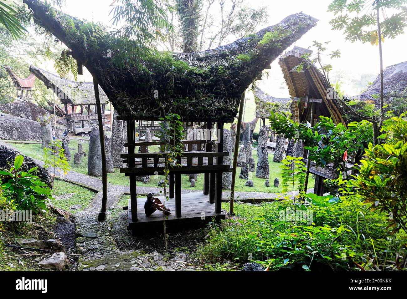 Touristen, Kind auf Familienurlaub, erkunden Bori Kalimbuang, megalithische Grabstätte umgeben von traditionellen tana toraja Gebäuden, sulawesi Stockfoto