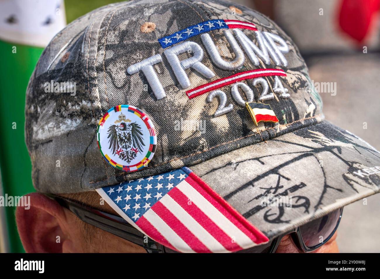 Reichsbürger-Treffen, Kundgebung auf dem Königsplatz, Trump 2024 Kappe aus den USA, München, 31. August 2024 Deutschland, München, 31. August 2024, Reichsbürger Treffen, Teilnehmer mit Trump 2024 Kappe aus den USA mit Reichsbürger Buttons, Reichsflagge und Kaiseradler, Kundgebung auf dem Königsplatz, die deutsche Reichsbürger-Szene traf sich unter dem Motto großes Treffen der 251 Bundesstaaten , sie erkannte die Bundesrepublik nicht als legitimen Staat an, sondern will zurück zum Deutschen Kaiserreich in den Grenzen von 1871, mit all seinen Fürstentümern plus Elsass-Lothringen, alle Flaggen der Stockfoto