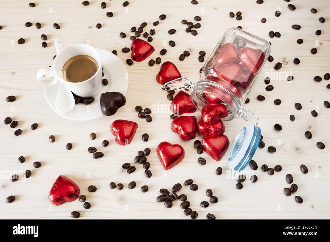 Rot Schokolade Herzen in einem Glas und einer Tasse Espresso Kaffee mit Kaffeebohnen auf eine Tabelle von oben gesehen Stockfoto