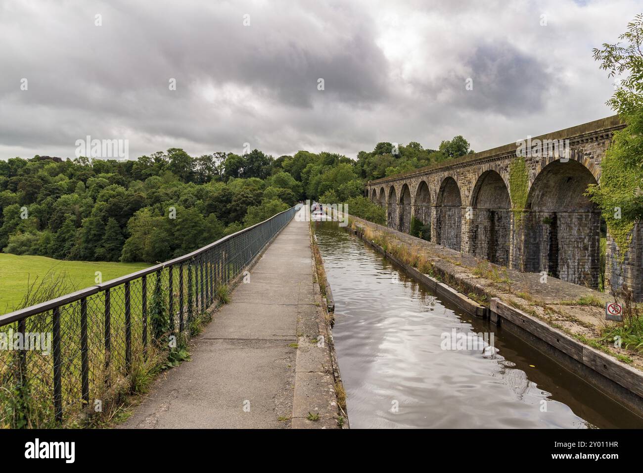 Chirk, Wrexham, Wales, Großbritannien, August 31, 2016: eine Person, die ein Schmalboot über den Chirk Aquädukt mit Menschen auf dem Bürgersteig und dem Chirk Viadukt lenkt Stockfoto