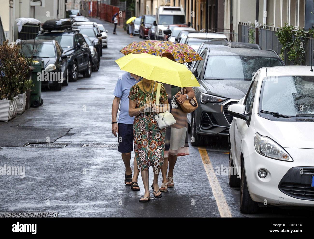 Menschen mit Sonnenschirmen gehen durch eine Straße in Diana Marina, Italien, 18.08.2024, Diano Marina, Ligurien, Italien, Europa Stockfoto