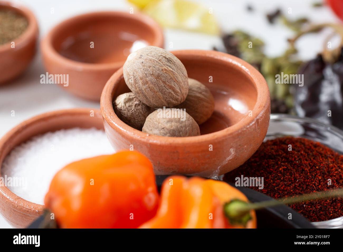 Eine Nahaufnahme ganzer Muskatnusskerne in einem Gewürzbecher. Stockfoto