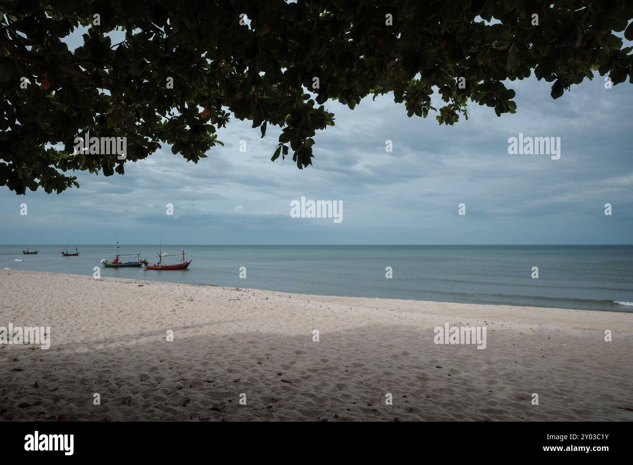 Eine ruhige Szene eines traditionellen Fischerbootes, das in den frühen Morgenstunden in Prachuap Khiri Khan, Thailand, durch ruhige Gewässer gleitet. Stockfoto