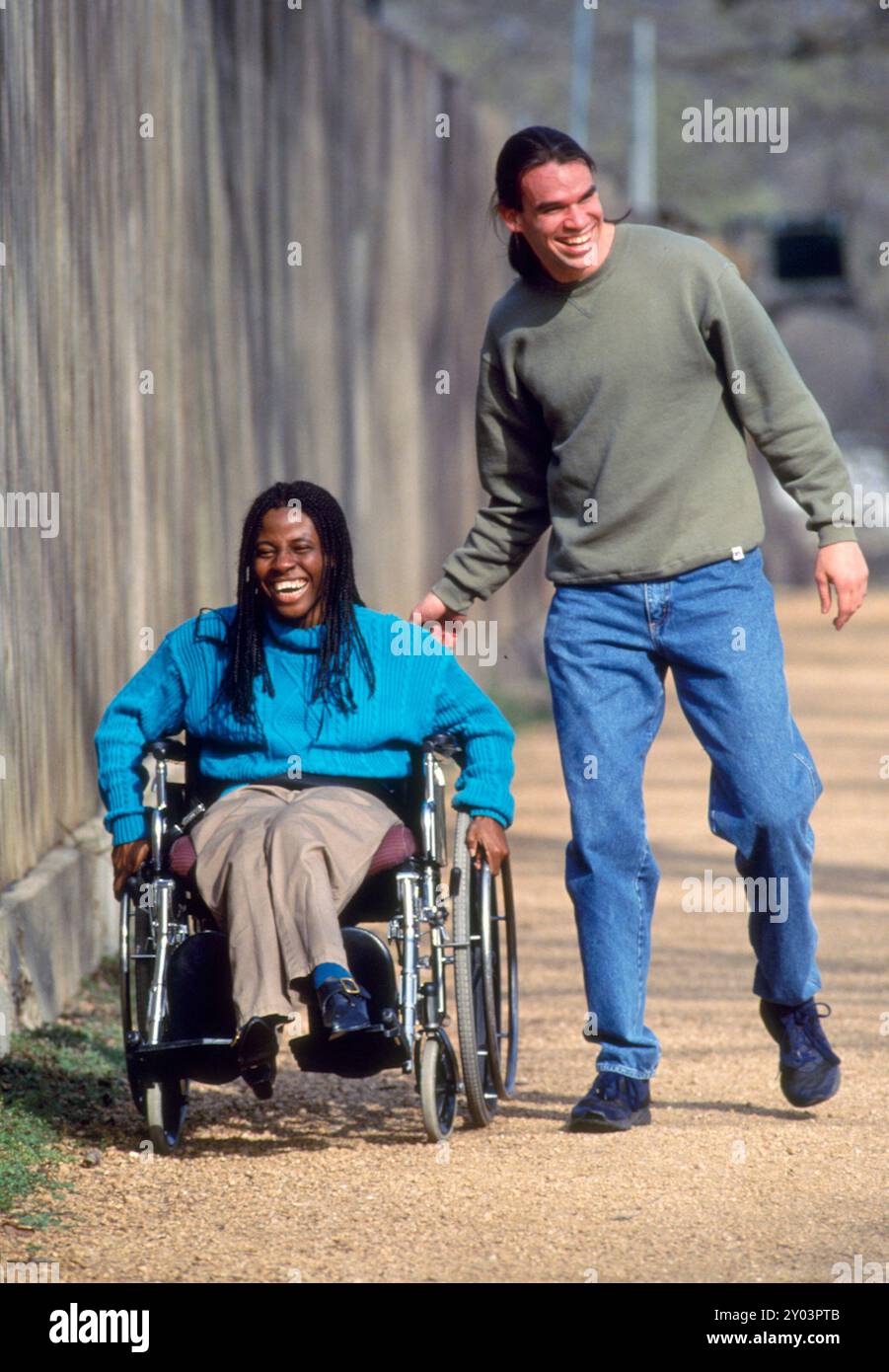 Behinderte Frau nigerianischer Herkunft in ihren 20ern genießt Zeit mit einem Freund auf einem Schotterwanderweg im Zilker Park in Austin, Texas Model veröffentlicht MR ©1994 ©Bob Daemmrich Stockfoto