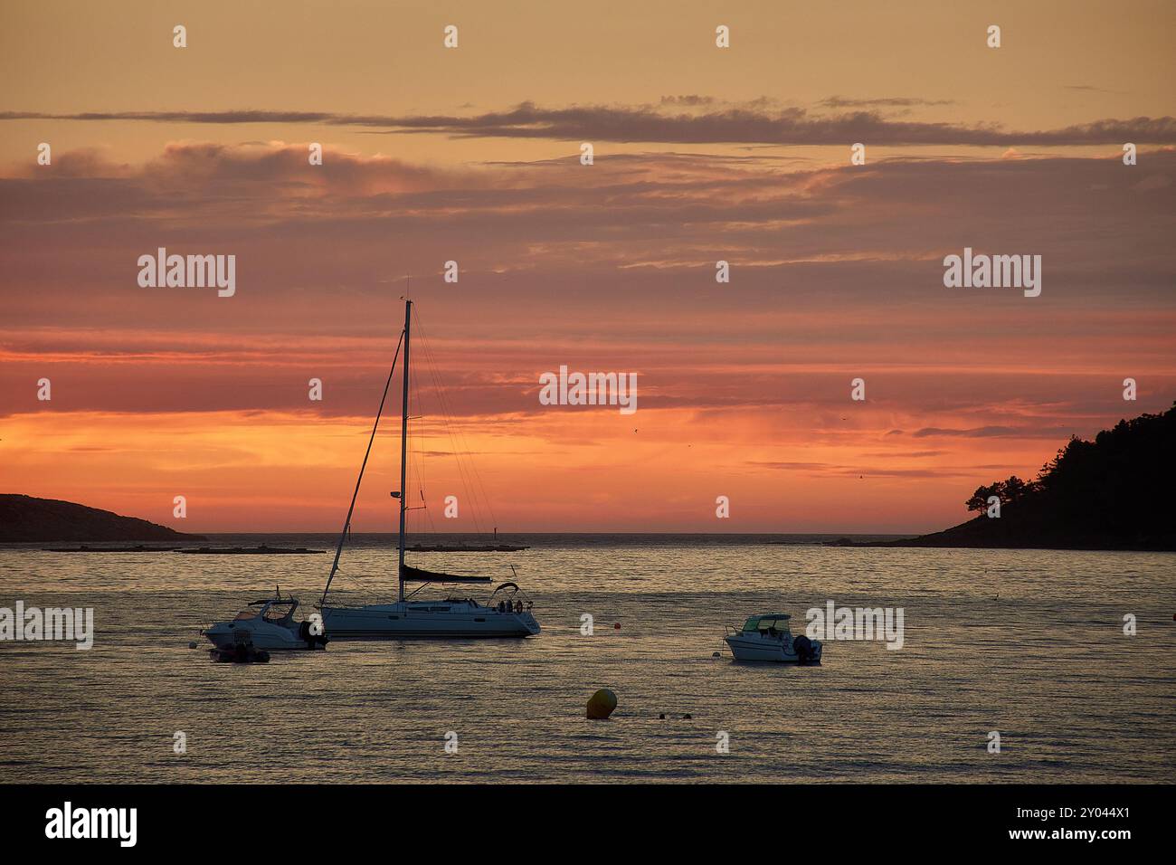 Ein roter Sonnenuntergang über Playa América in Nigrán, Spanien, mit der Silhouette der Las Estelas Inseln im Hintergrund. Der Himmel ist in tiefen Tönen gemalt Stockfoto