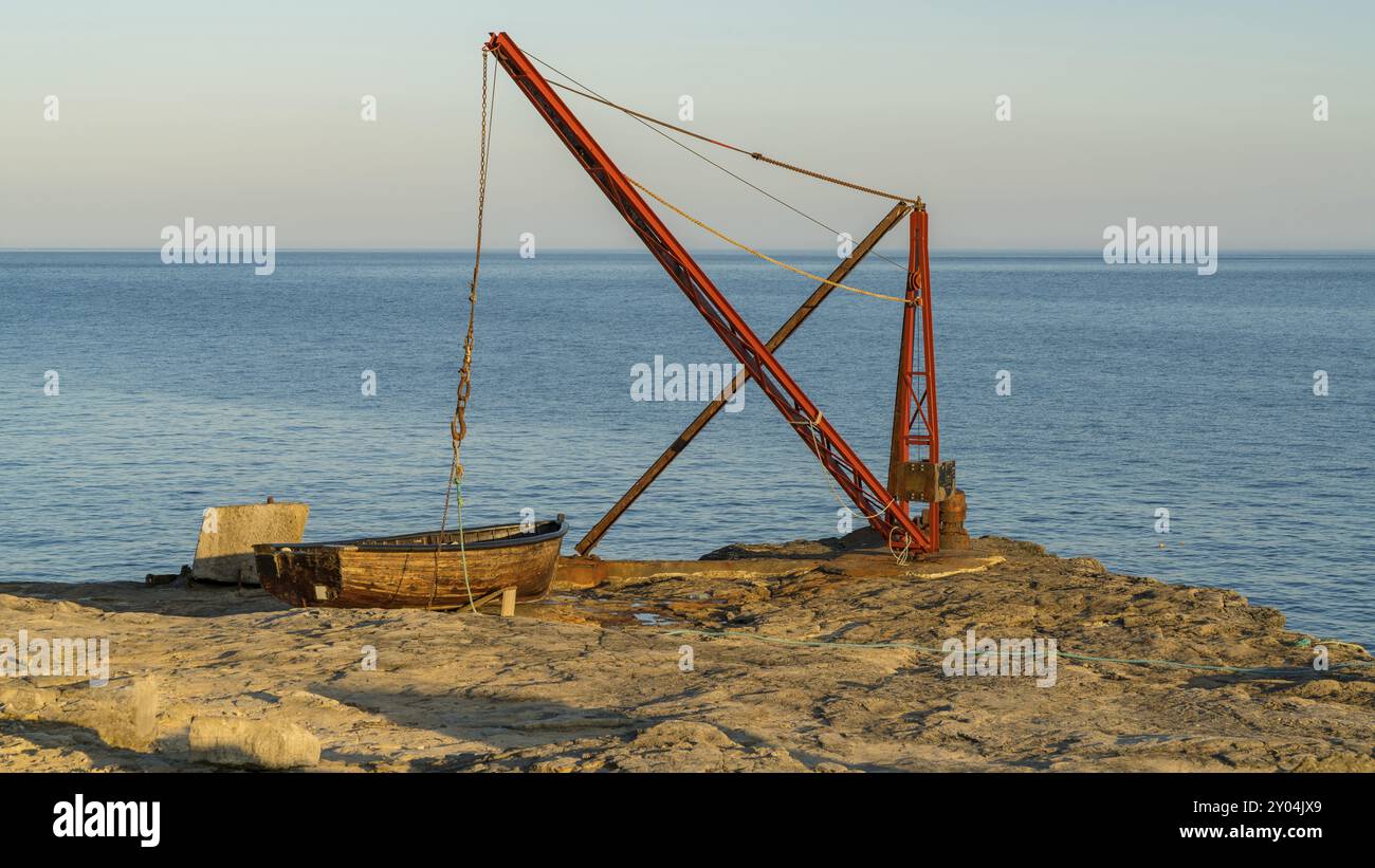 Ein Fischerboot und ein Kran in der Nähe von Portland Bill Leuchtturm, Jurassic Coast, Dorset, Großbritannien Stockfoto