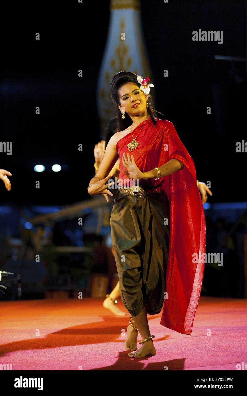 Bangkok, Thailand, 11. April 2007: Eine wunderschöne thailändische Tänzerin in roten und grünen traditionellen Kleidern tanzt bei einer Nachtausstellung im Freien vor Stockfoto