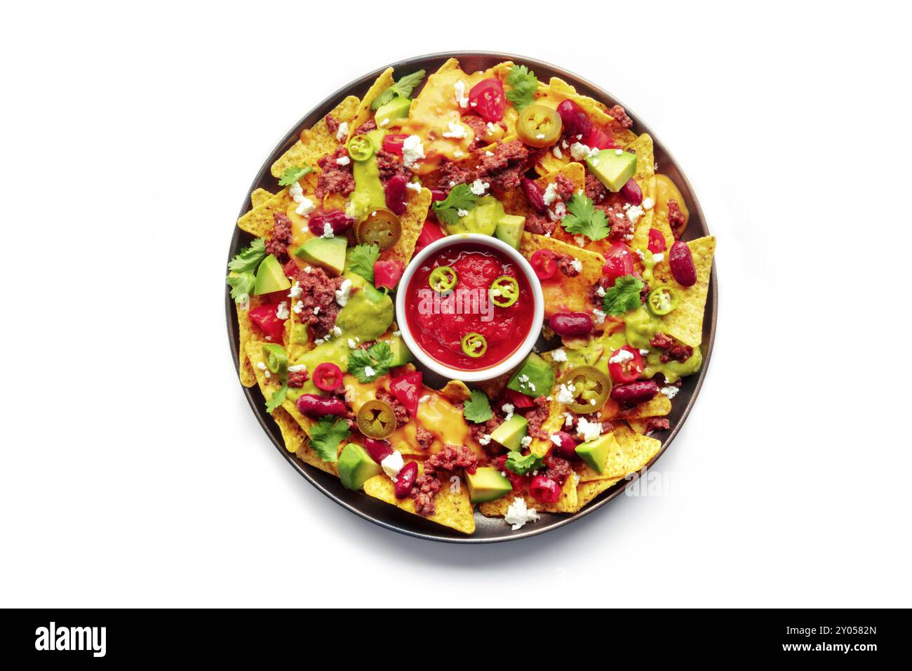 Nachos geladen. Mexikanische Nacho-Chips mit Rindfleisch, oberirdischer Flachschuss mit Guacamolensauce, Käsesalsa, Bohnen und Paprika, isoliert auf einem weißen Backgr Stockfoto