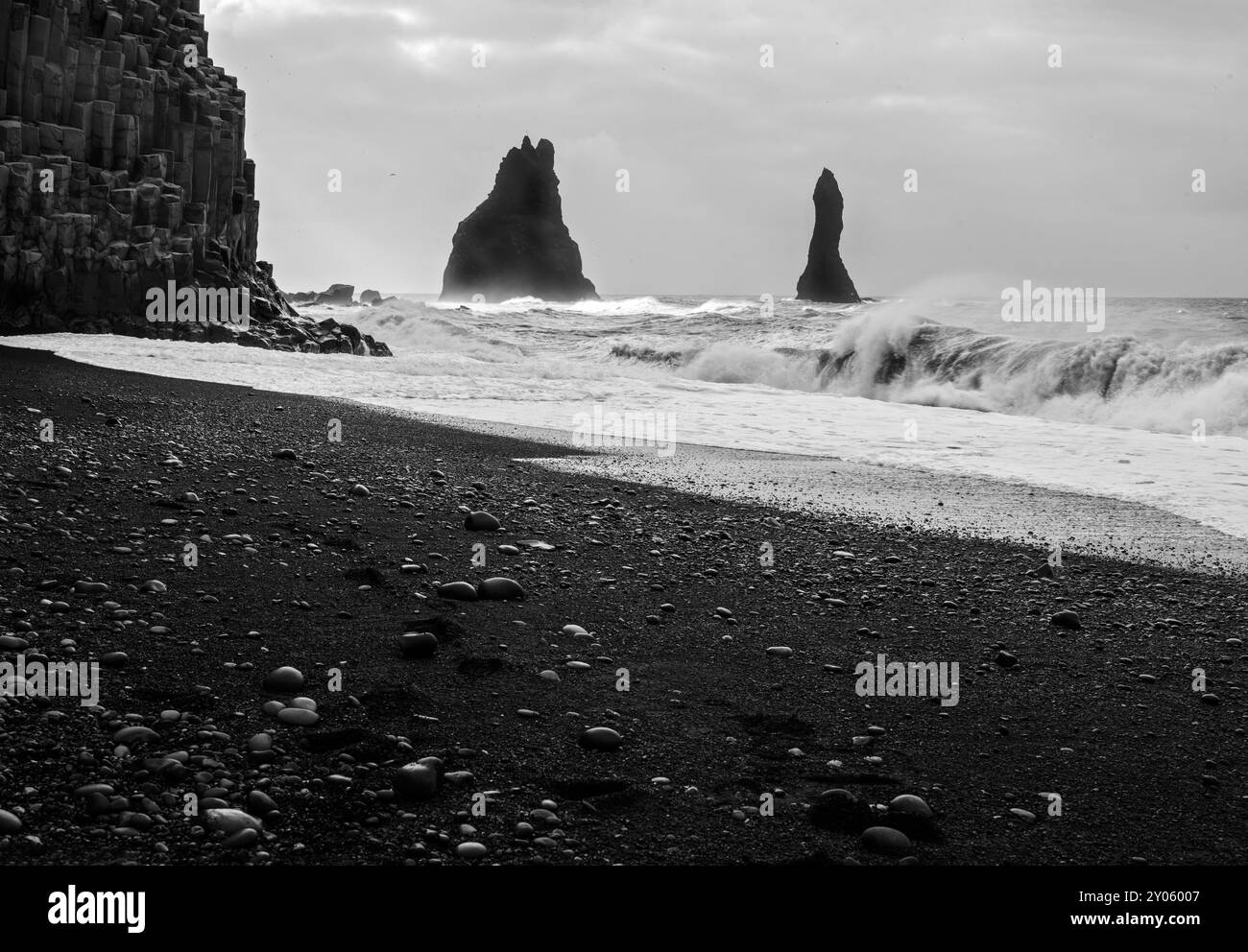 Reynisdrangar - Basaltmeerstapel - und Basaltsäulen am Raynisfjara (schwarzer Sandstrand) in Vik, Süd-Island. Stockfoto