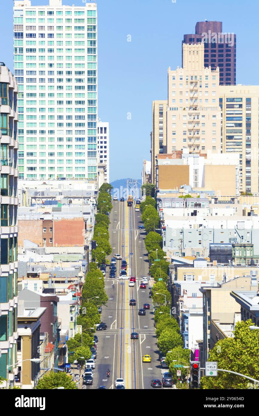 Fernblick über die California Street mit der berühmten Cable Car und der Spitze der Bay Bridge zwischen Wohnhäusern an klaren, sonnigen Tagen in Sa Stockfoto