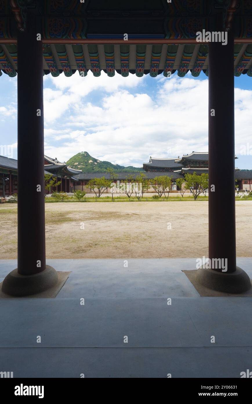 Säulen stützen die farbenfrohen Traufe im unbefestigten Innenhof des Gyeongbokgung Palace, einer Touristenattraktion, in Seoul, Südkorea und Asien Stockfoto