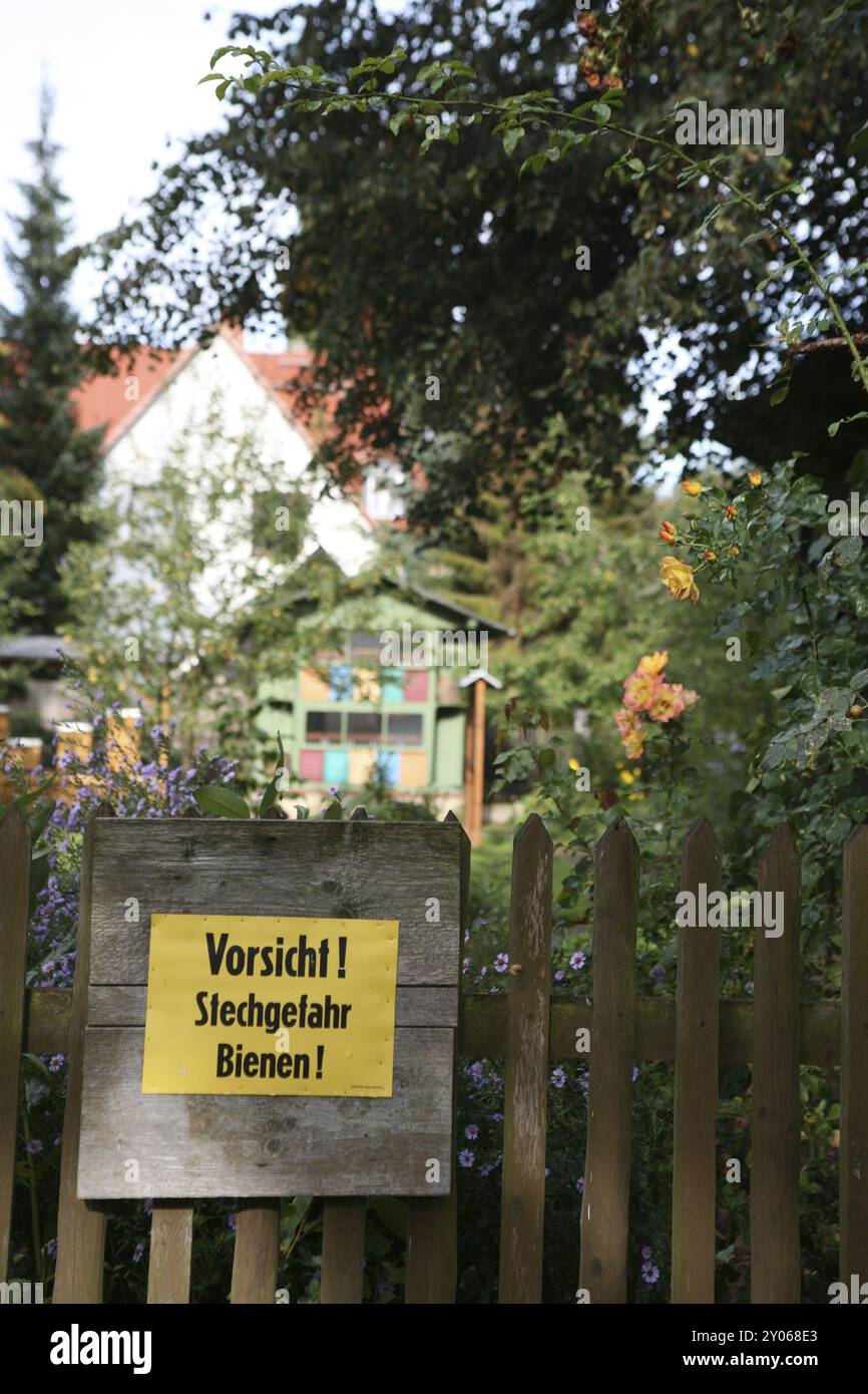 Bienenwarnschild an einem Gartenzaun Stockfoto