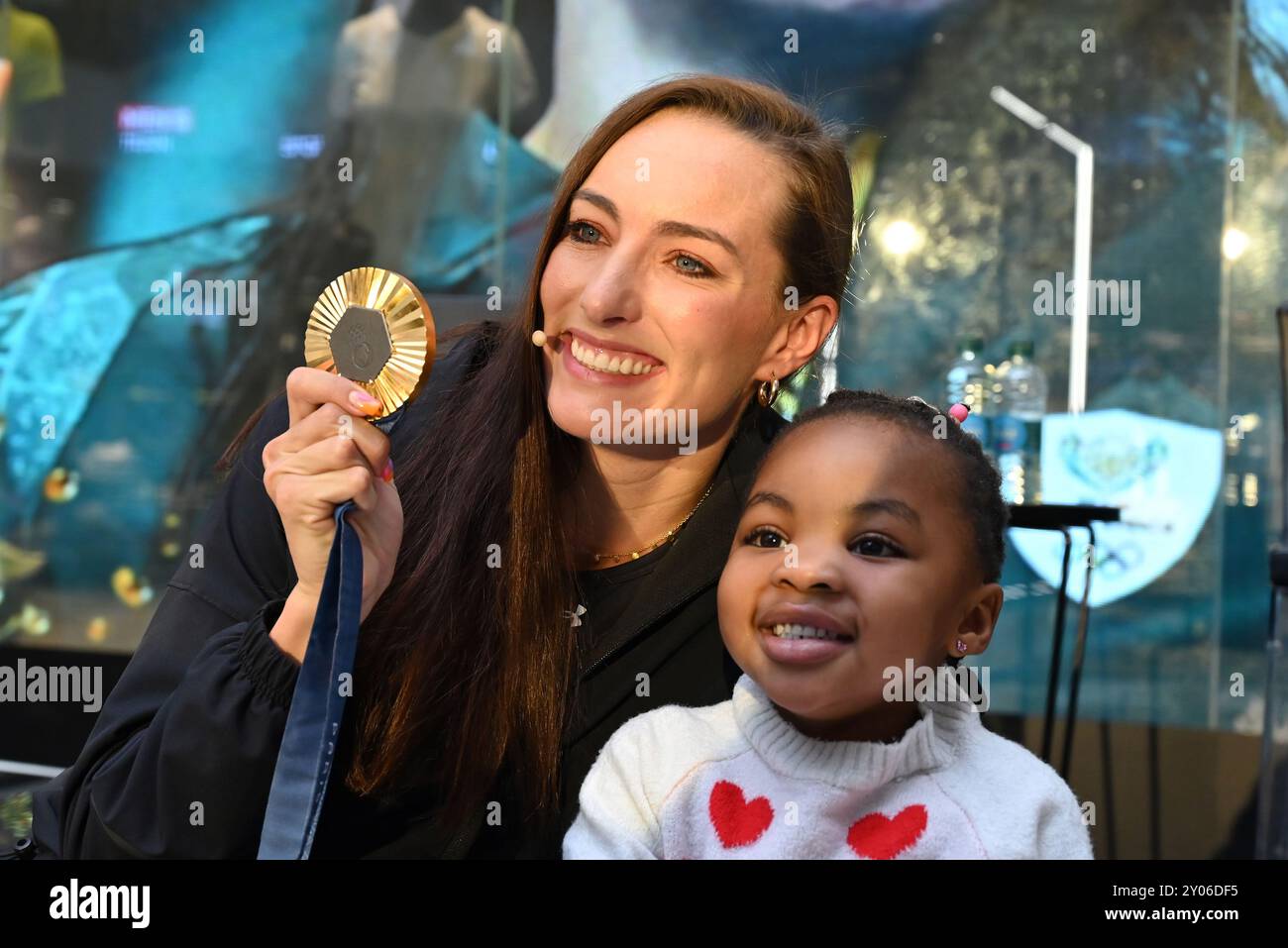 Johannesburg, Gauteng, Südafrika. 31. August 2024. Die Olympiasiegerin TATJANA SMITH zeigt die dreijährige ASANTE KETEYI ihre Medaille bei einem Welcome Home Event, das ihr Sponsor Under Armour in ihrem Flagship Store in Sandton City, Johannesburg, ausgetragen hat. (Kreditbild: © Neil McCartney/ZUMA Press Wire) NUR REDAKTIONELLE VERWENDUNG! Nicht für kommerzielle ZWECKE! Stockfoto