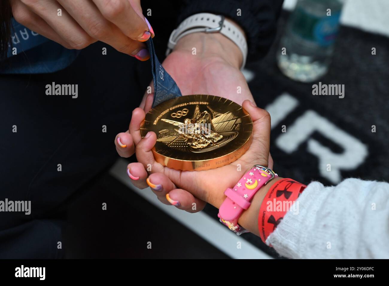 Johannesburg, Gauteng, Südafrika. 31. August 2024. Die Olympiasiegerin TATJANA SMITH zeigt die dreijährige ASANTE KETEYI ihre Medaille bei einem Welcome Home Event, das ihr Sponsor Under Armour in ihrem Flagship Store in Sandton City, Johannesburg, ausgetragen hat. (Kreditbild: © Neil McCartney/ZUMA Press Wire) NUR REDAKTIONELLE VERWENDUNG! Nicht für kommerzielle ZWECKE! Stockfoto