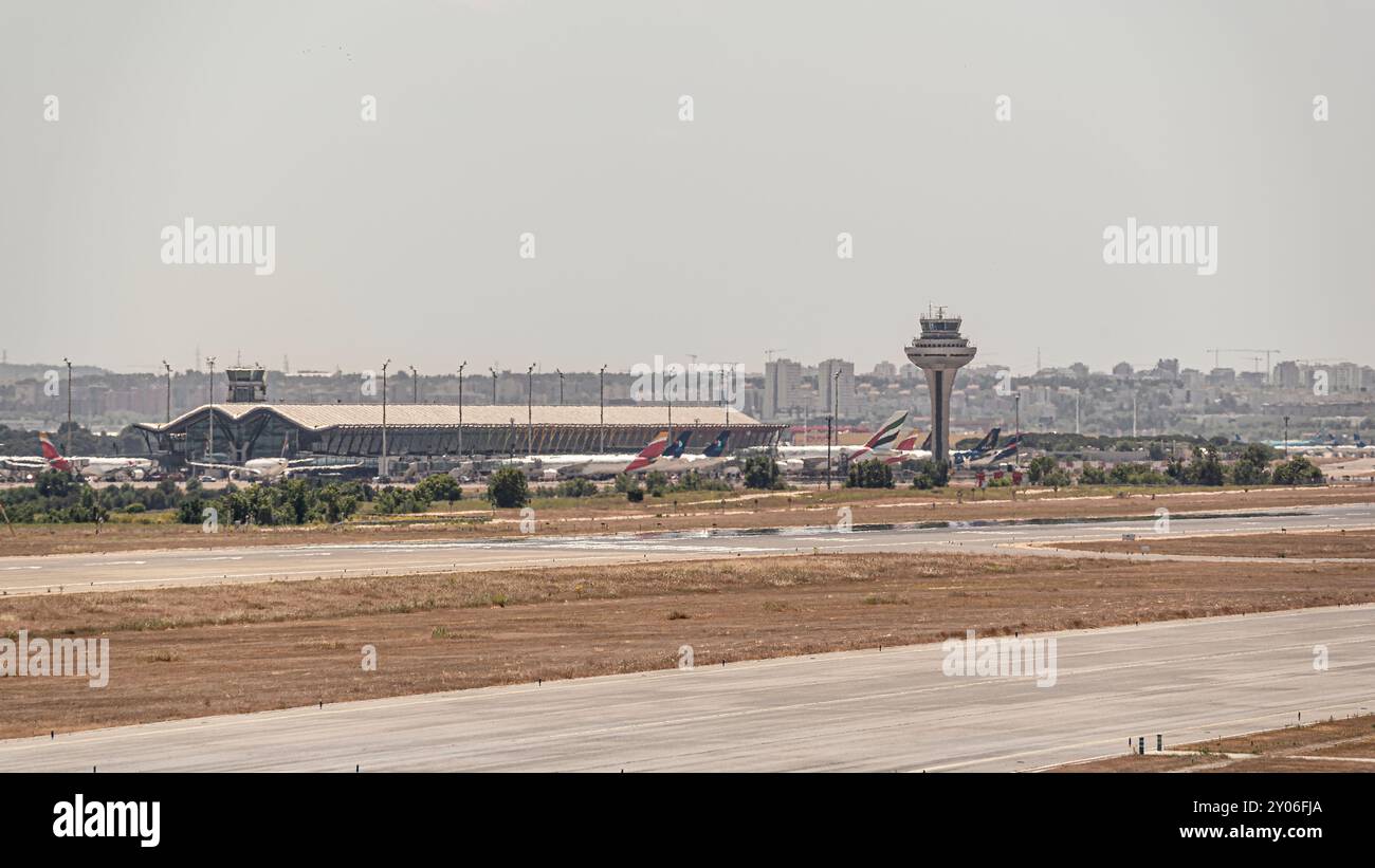 Madrid, Spanien; 18.05.2024: Flughafen Adolfo Suarez Madrid Barajas Kontrollturm in der Nähe des Terminals und der Start- und Landebahn mit einigen Flugzeugen Stockfoto