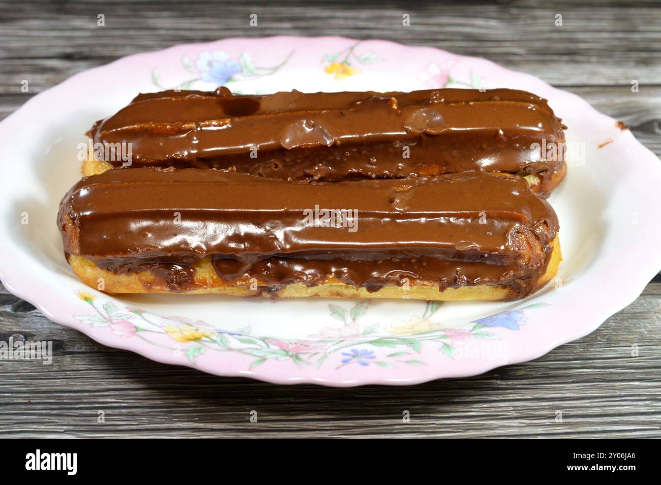 Schokoladen-Eclair-Kuchen gefüllt mit Sahne und aus Butter, Salz, Mehl, Eiern, Milch, Schlagsahne, Zucker, Vanille und Choux Gebäck und Schokolade PA Stockfoto