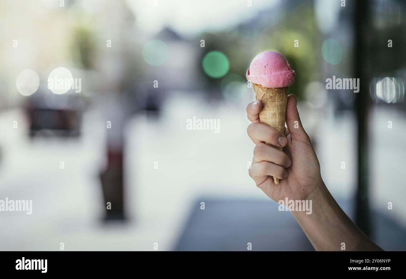 Frau hält Erdbeereis in ihrer Hand, sonnigen Sommertag, verschwommenen Hintergrund Stockfoto