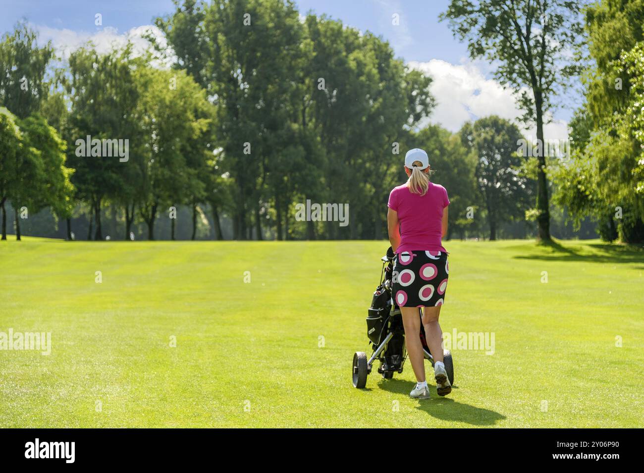 Rückansicht des Golfers mit Trolley auf dem Platz Stockfoto
