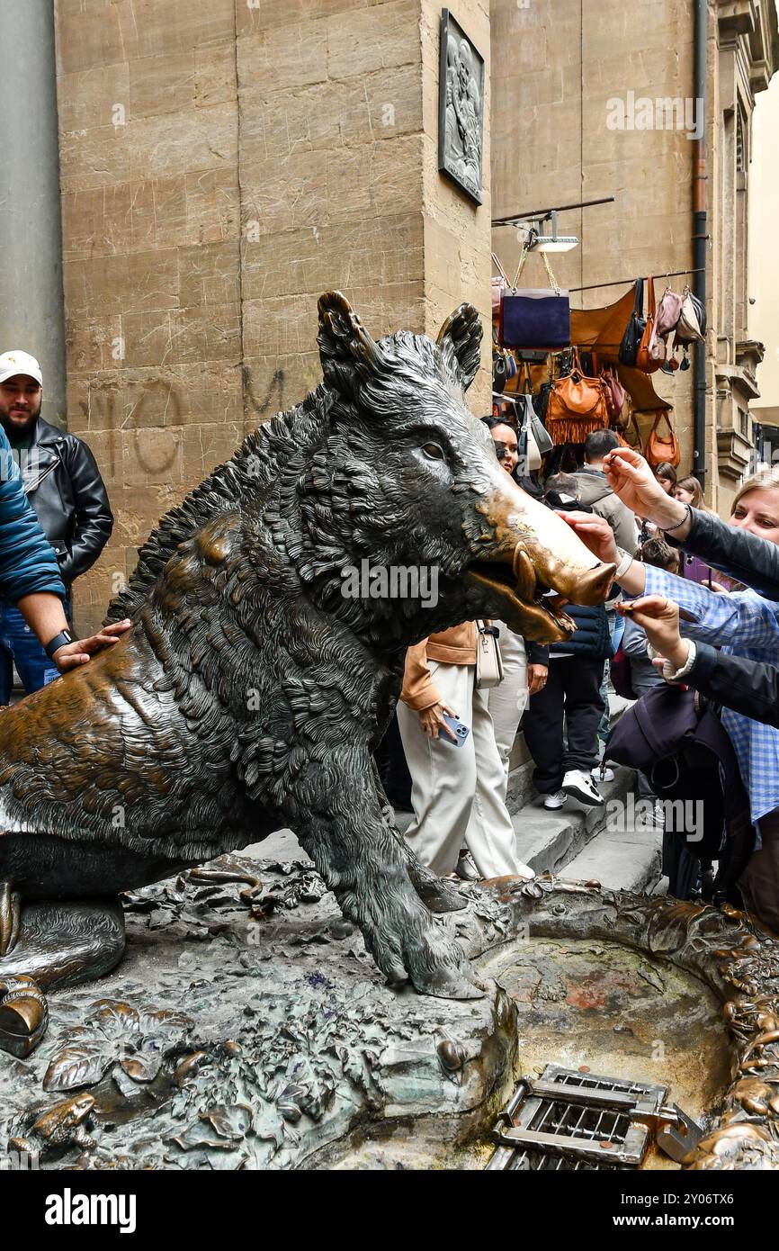 Touristen, die das Glücksritual am Porcellino-Brunnen in der Loggia des Mercato Nuovo oder Mercato del Porcellino, Florenz, Italien, verfolgen Stockfoto