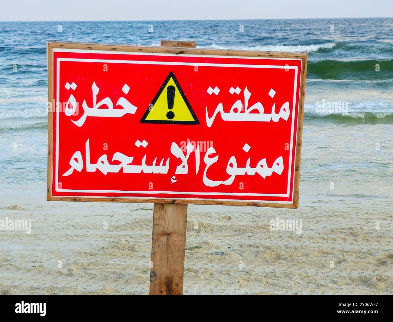 Übersetzung des arabischen Textes (gefährlicher Bereich, Baden verboten), kein Badezeichen, Schild nicht schwimmen am Strand von Alexandria, Schwimmen in Gefahrenzonen Stockfoto