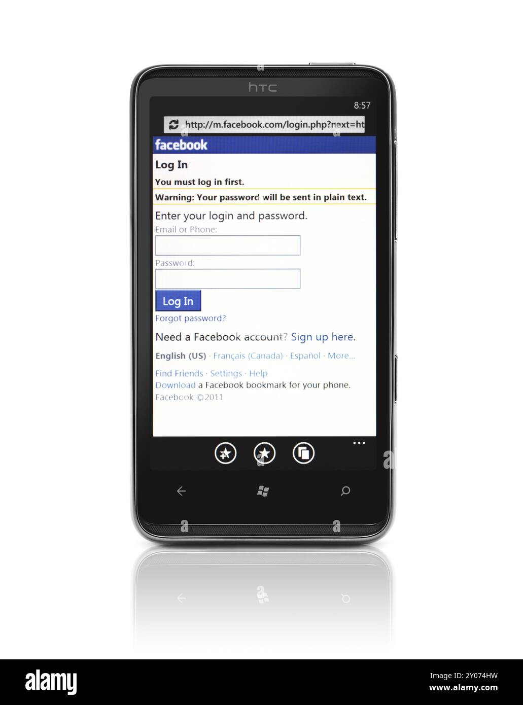 Windows 7 Telefon. HTC HD7-Smartphone mit Facebook-Anmeldeseite auf dem Display isoliert mit Beschneidungspfad auf weißem Hintergrund. Hochwertige Fotos Stockfoto