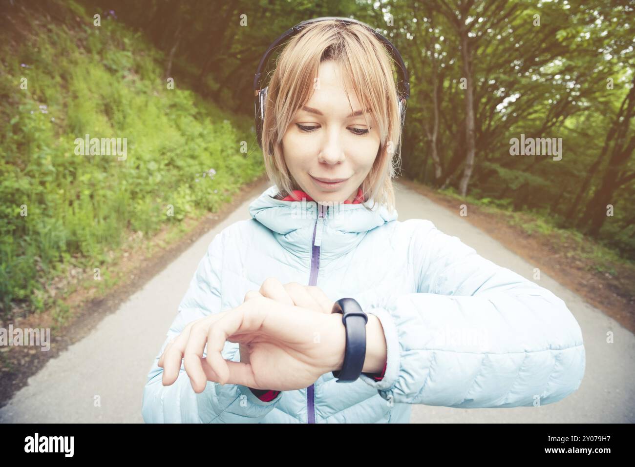 Porträt Junge Fitness-Frau, die ihre Smartwatch ansieht, während sie eine Pause vom Sporttraining macht. Sportsfrau überprüft Puls auf Fitness-Smartwatch d Stockfoto