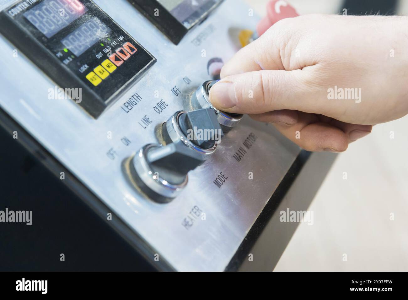 Eine Nahaufnahme der nicht gepflegten Hände des echten Zimmermanns rundet die Verarbeitung der Spanplattendetails der Möbel ab, indem sie die Kante abschneidet Stockfoto