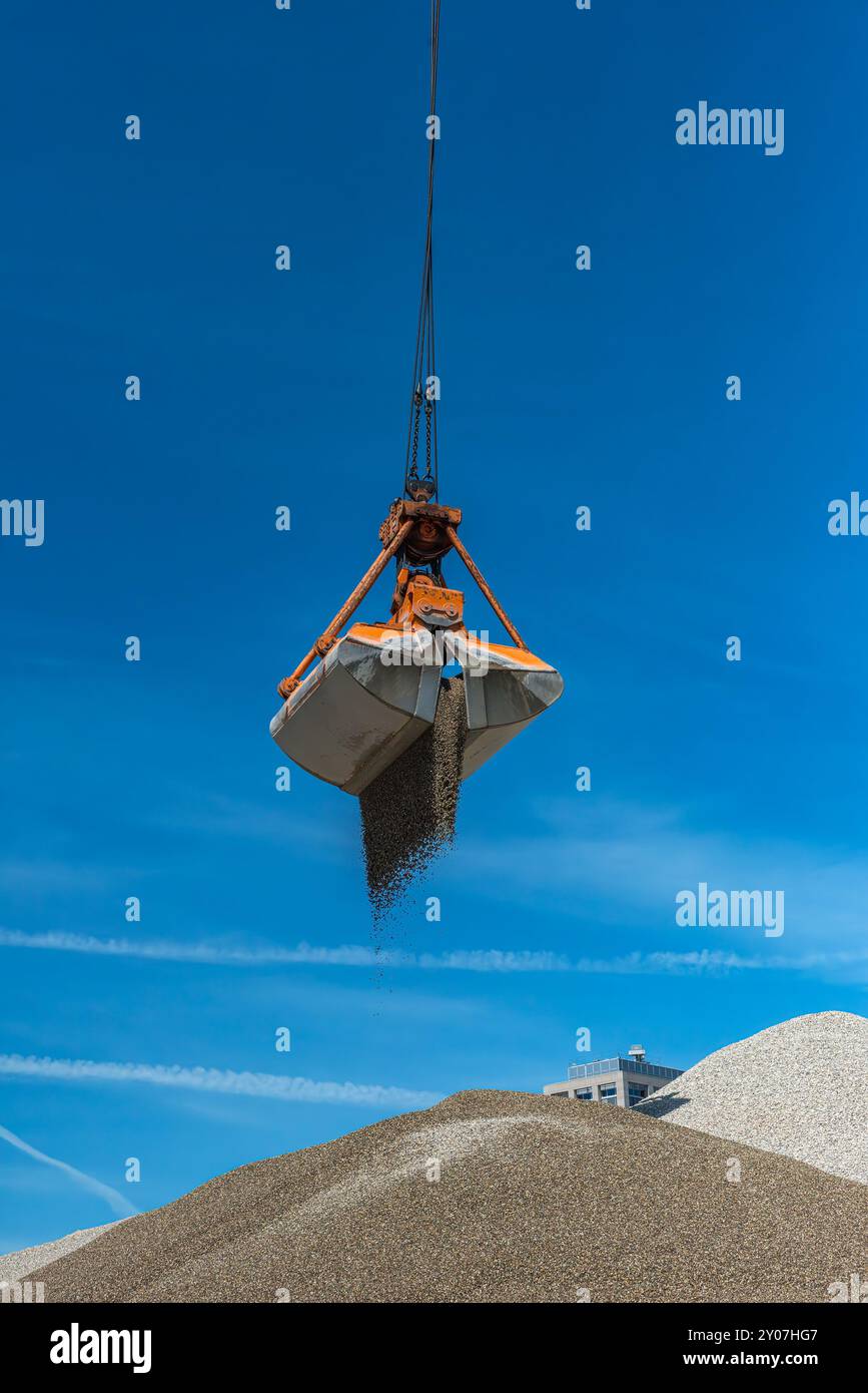 Greifkran füllt Sand auf einem Hügel Stockfoto