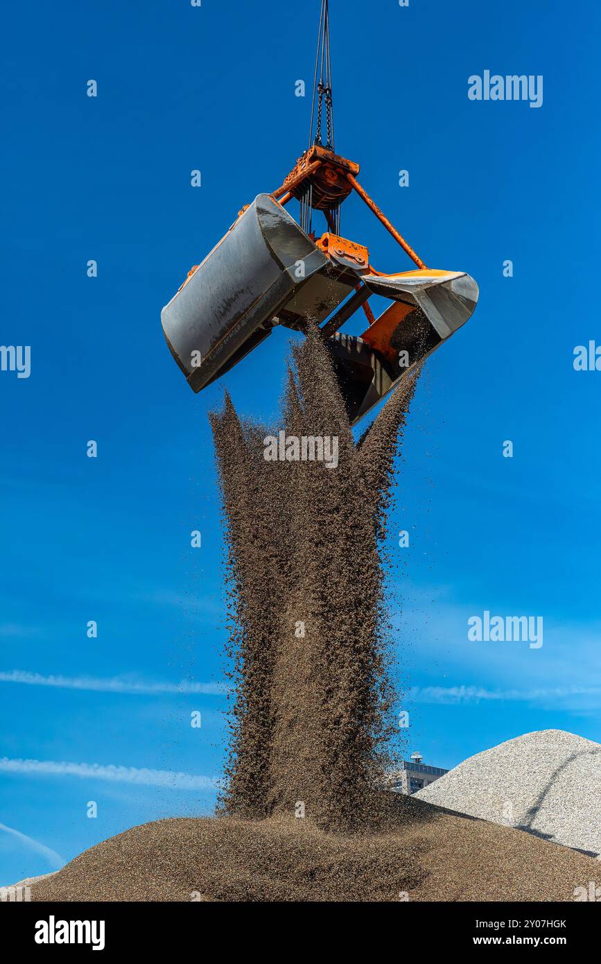 Greifkran füllt Sand auf einem Hügel Stockfoto