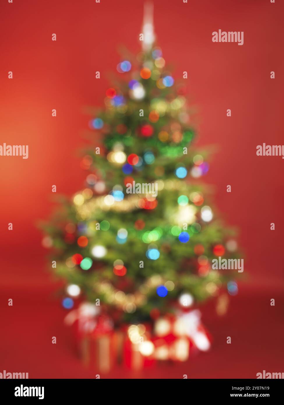 Out of Focus dekorierten Weihnachtsbaum auf rotem Hintergrund isoliert Stockfoto