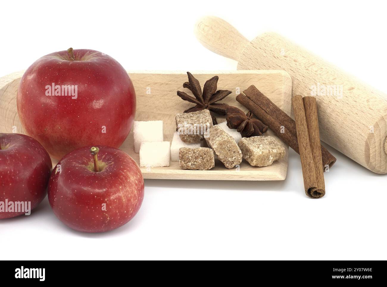 Rote Äpfel, Zucker, Zimt-Sticks und Anissterne in der Nähe von Nudelholz in einem Lebensmittel Stillleben auf weiß, Konzept eines Backapfelkuchen Stockfoto