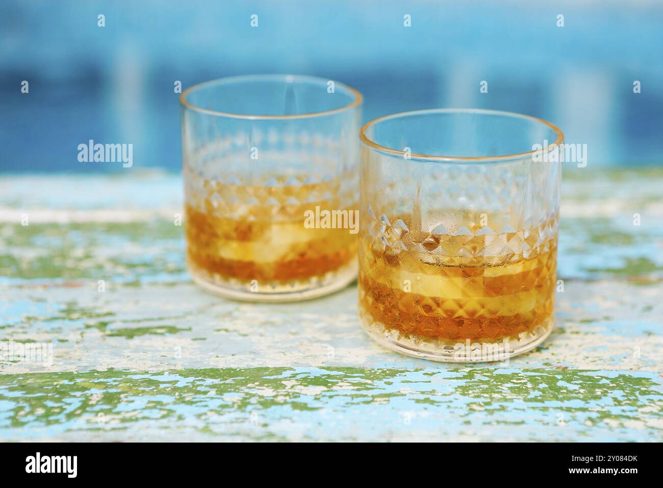 Zwei Gläser Whisky am Pool. Auf dem blauen Hintergrund Stockfoto