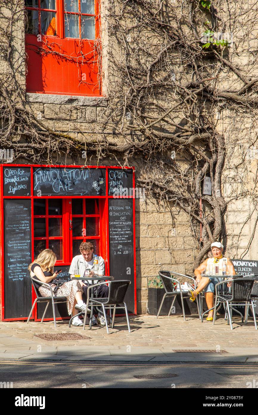 In der ehemaligen Textilfabrik, heute ein Café und eine Bar in der Yorkshire Marktstadt Hebden Bridge, essen und trinken die Menschen in der Sommersonne Stockfoto