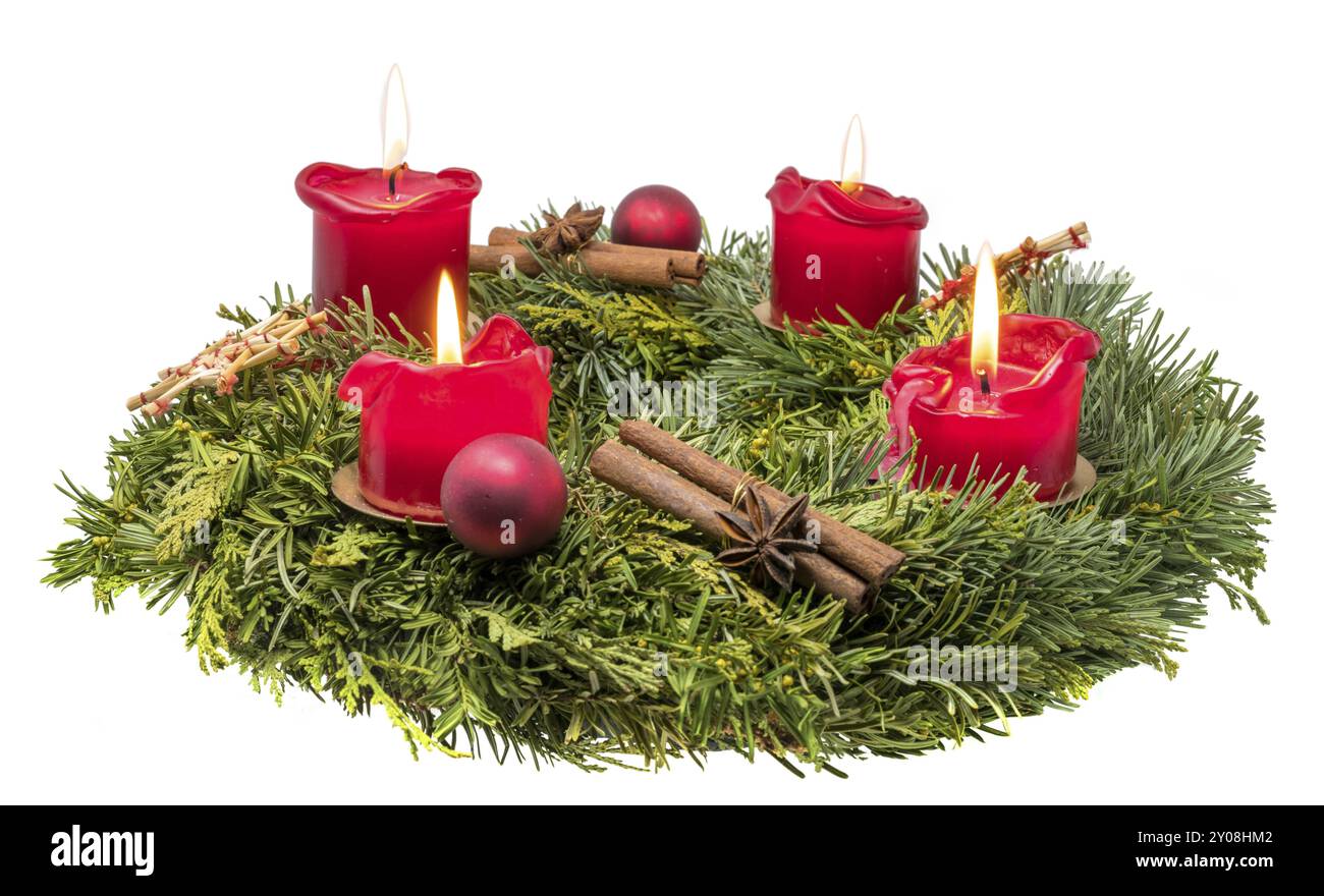 Dekorierter Adventskranz aus Tannenzweigen mit brennenden roten Kerzen auf weißem Hintergrund Stockfoto