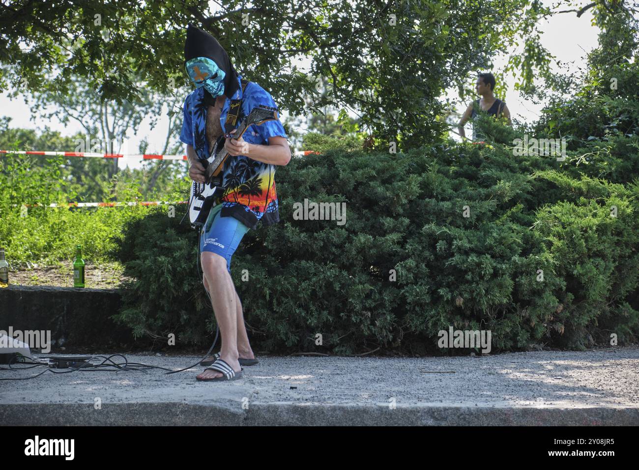 Deutschland, Berlin, 21.07.2024, Sonntagnachmittag im Mauerpark, Gitarrist mit Maske, Europa Stockfoto