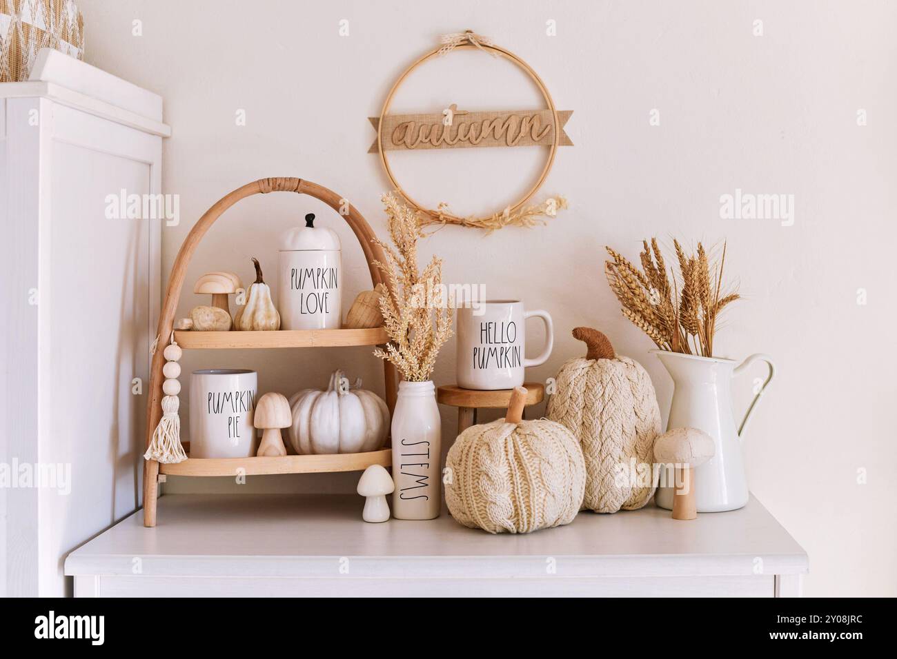 Dossenheim, Deutschland - 1. September 2024: Herbstdekor im Boho-Stil mit Rae Dunn Tassen mit Text, Kürbissen, Tassen und getrockneten Blumen Stockfoto
