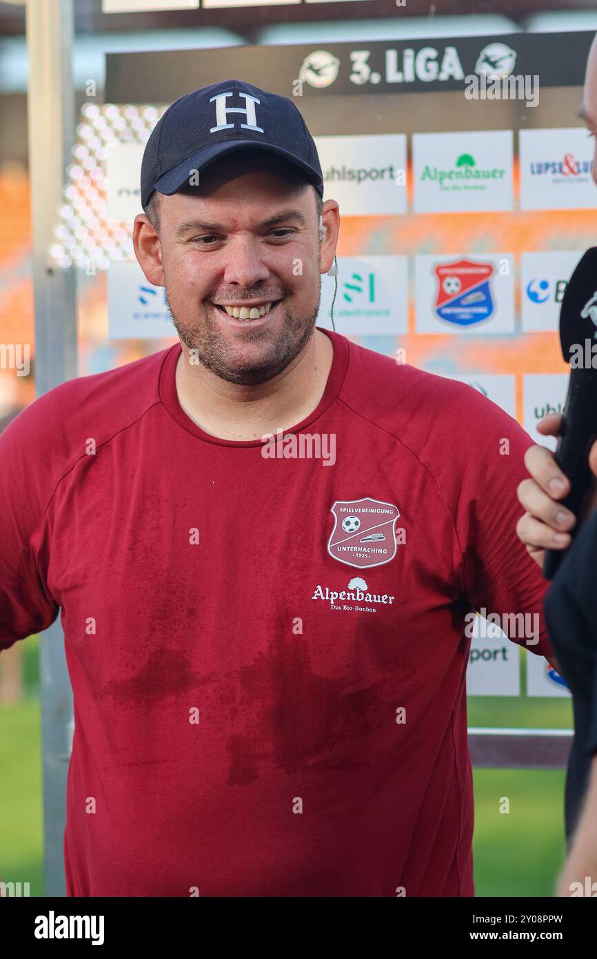 Marc Unterberger (SpVgg Unterhaching, Chef-Trainer) beim Interview nach dem Spiel, lacht, lachend, SpVgg Unterhaching vs. Rot-Weiss Essen, Fussball, 3. Liga, 4. Spieltag, Saison 24/25, 01.09.2024, DFL-VORSCHRIFTEN VERBIETEN JEDE VERWENDUNG VON FOTOGRAFIEN ALS BILDSEQUENZEN, Foto: Eibner-Pressefoto/Jenni Maul Stockfoto