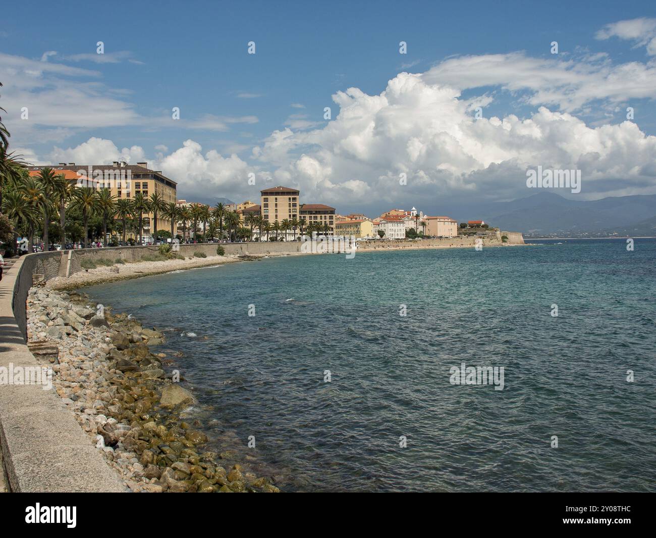 Schöne Küstenstadt mit Promenade und Gebäuden am blauen Meer unter teilweise bewölktem Himmel, Ajaccio, Korsika, Mittelmeer, Frankreich, Europa Stockfoto