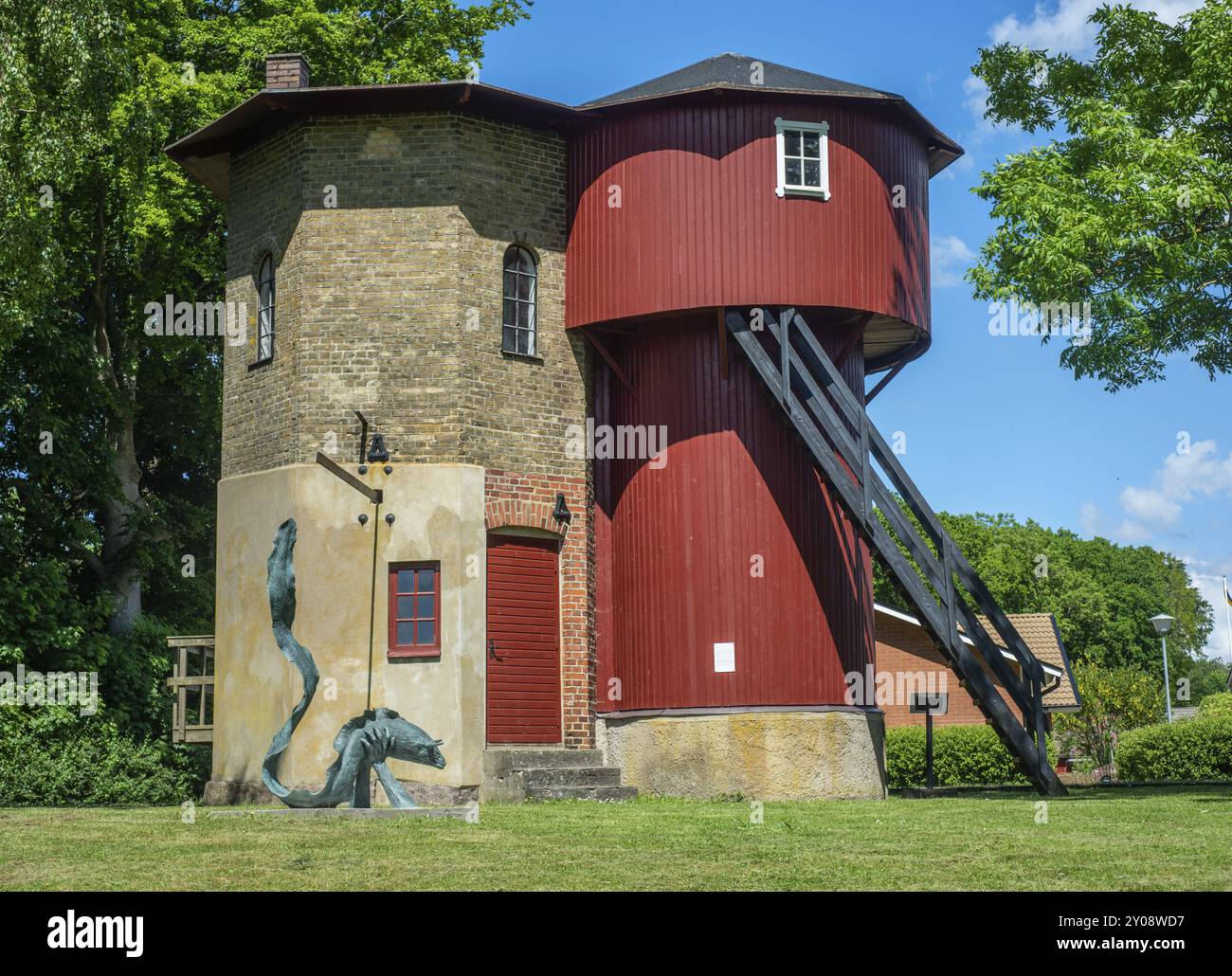Historisches Pumpenhaus zum Auffüllen von Wasser auf Dampflokomotiven. Im Vordergrund eine Statue eines mythologischen Aals mit Hörnern. In Vollsjoe, Skane County, Stockfoto