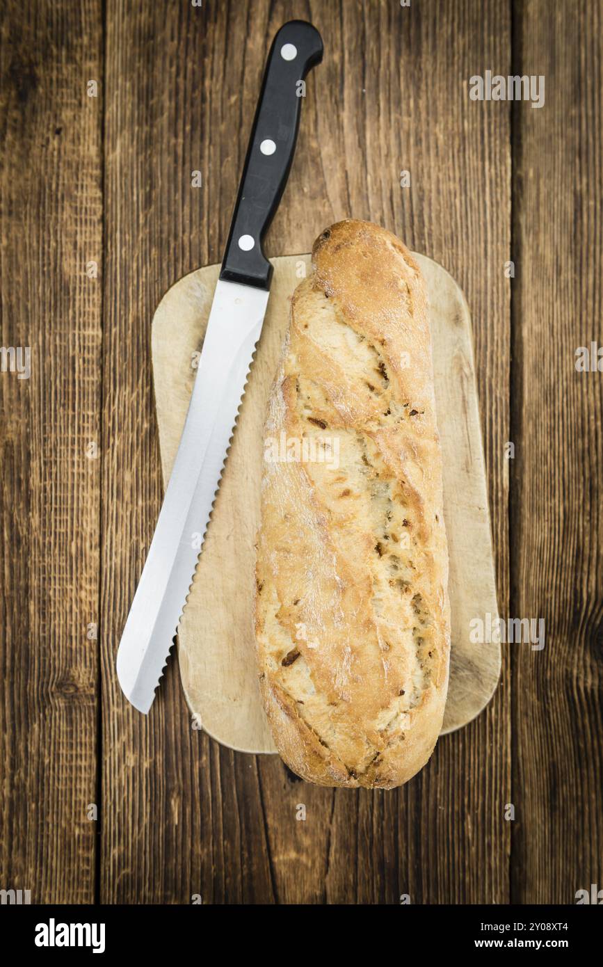 Teil des hausgemachten Baguette auf hölzernem Hintergrund (selektiver Fokus, Nahaufnahme) Stockfoto