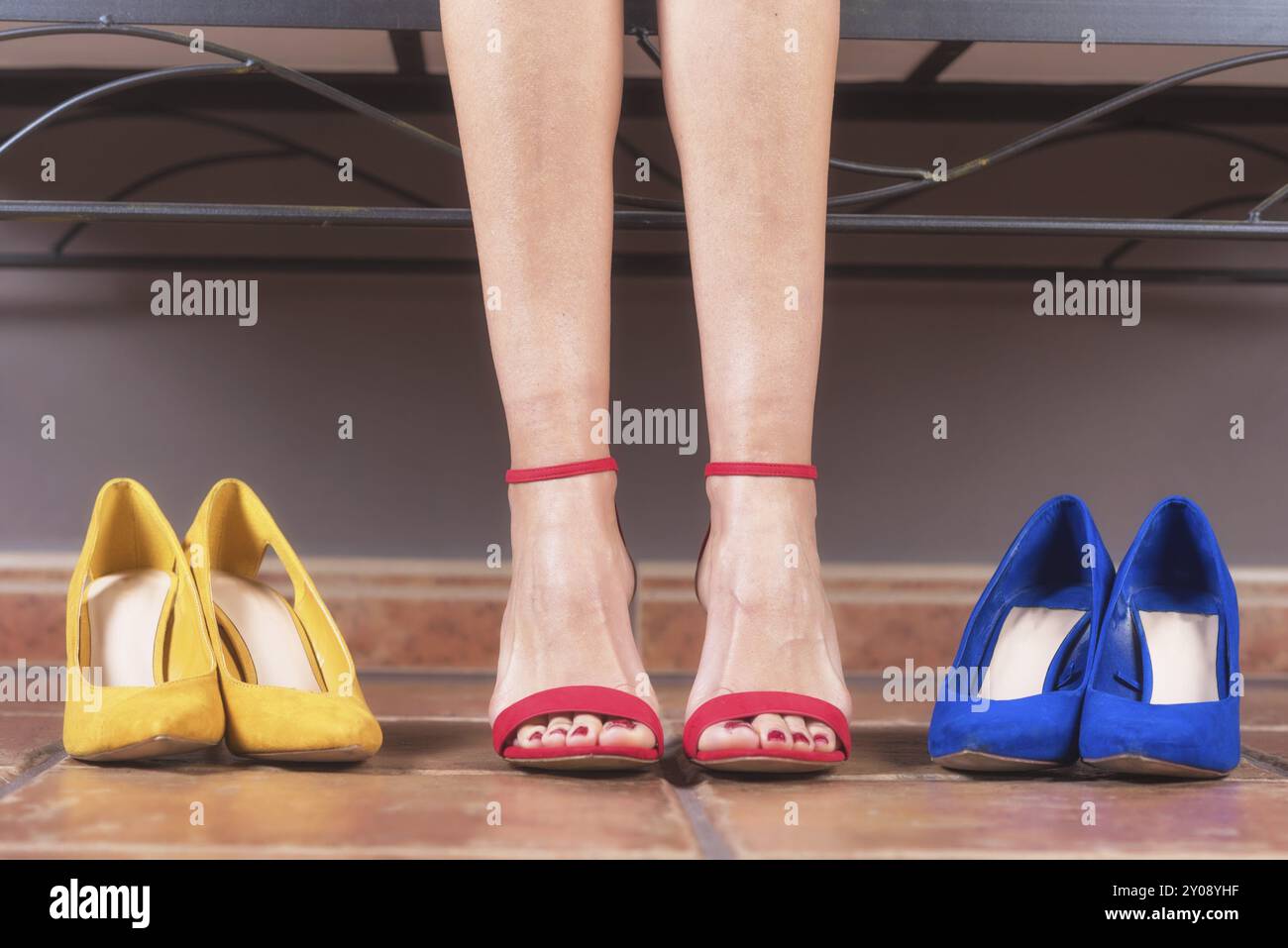 Frau mit perfekten schlanken Beinen, die verschiedene Schuhe mit hohem Absatz anprobiert. Einkaufskonzept Stockfoto