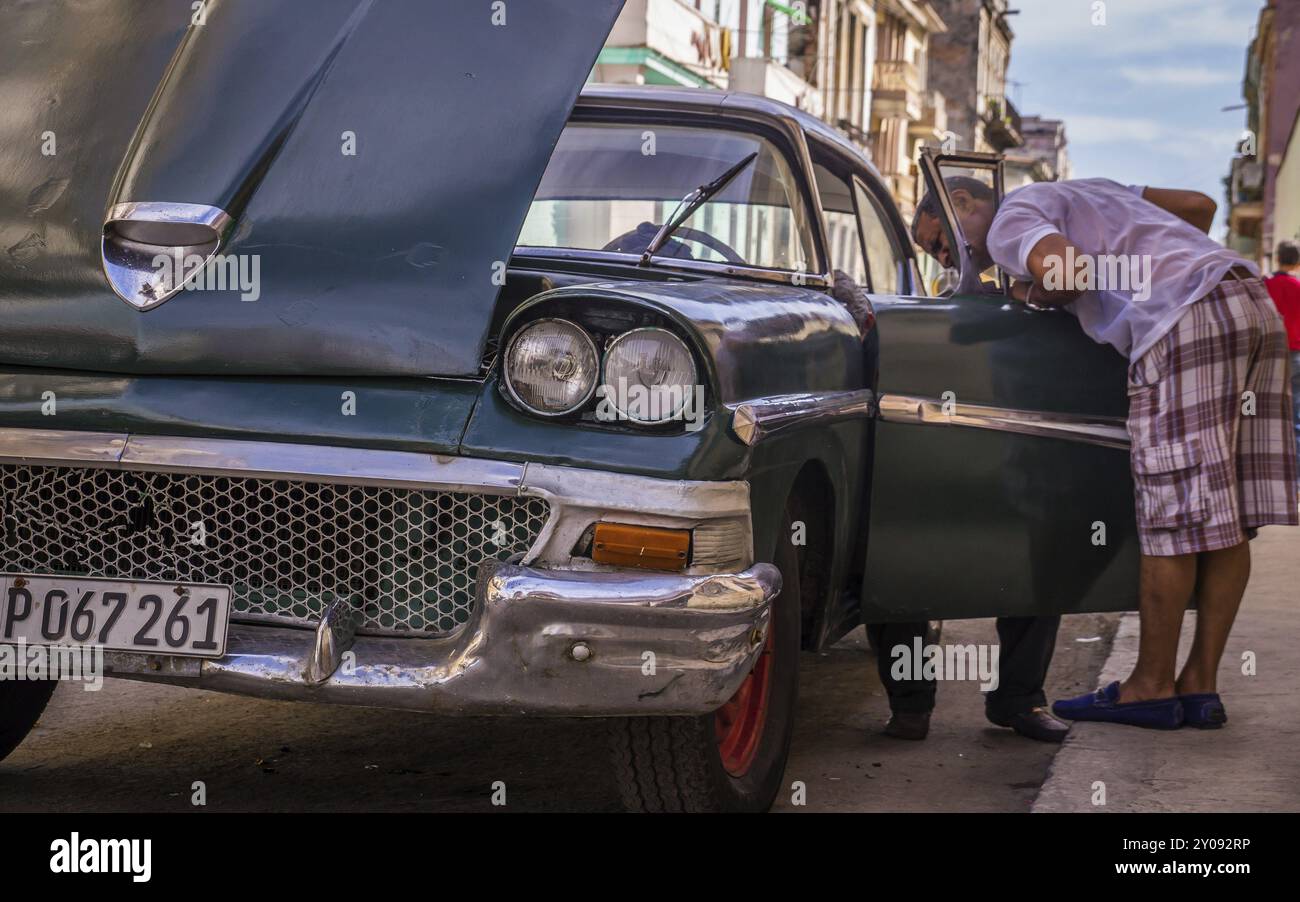 Havanna, Kuba am 23. Dezember 2015: Kubanischer Mechaniker versucht, einen amerikanischen Oldtimer aus den 1950er Jahren zu reparieren, der einen Ausfall hat. Die meisten Autos in Kuba sind Oldtim Stockfoto