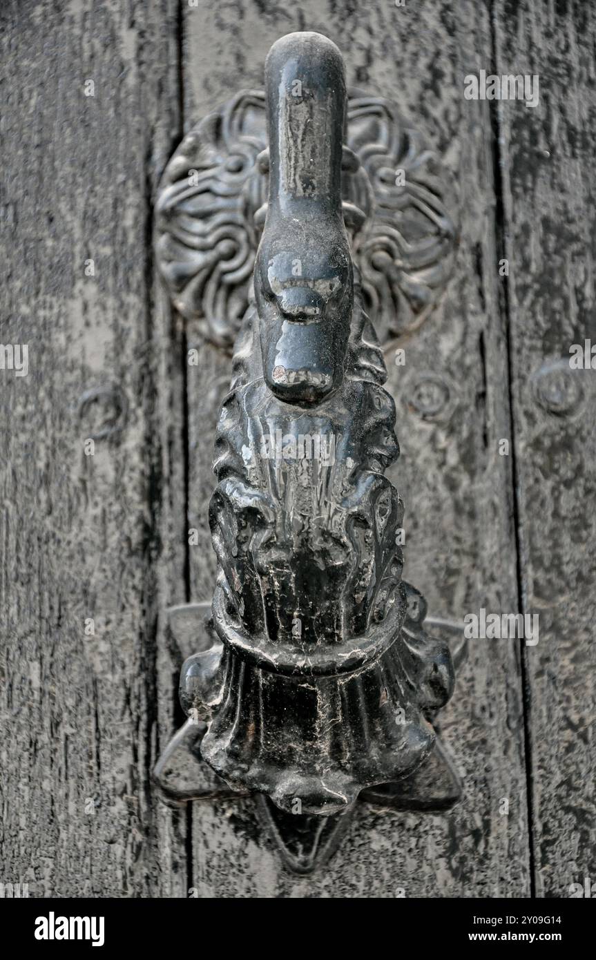 Ein sehr alter, modischer Türklopfer in einer Holztür Stockfoto