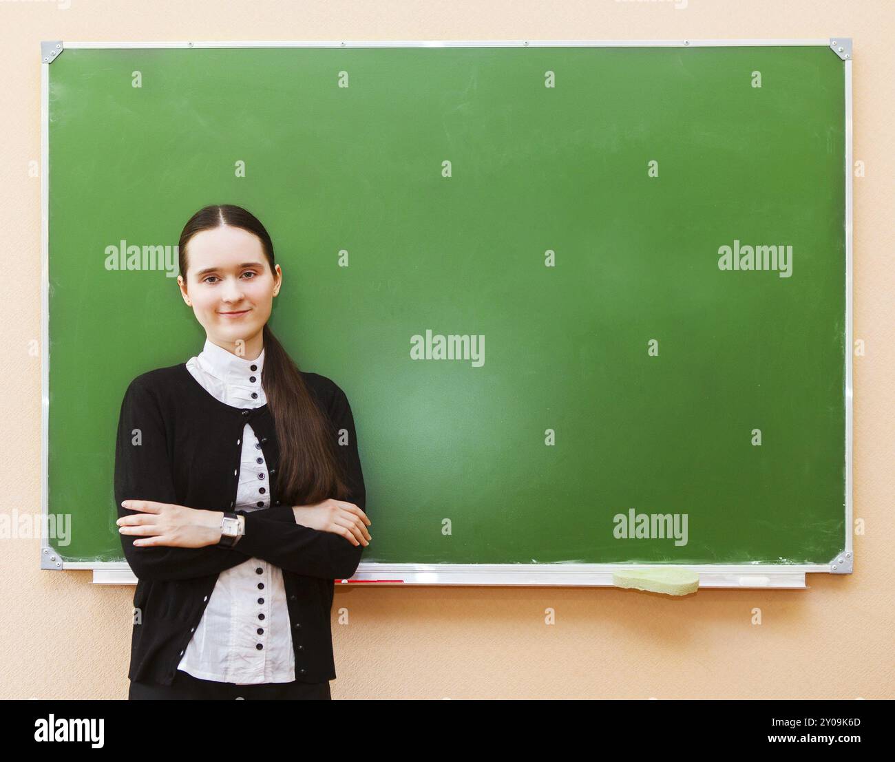 Glückliche Schüler Mädchen stehen in der Nähe von sauberen Tafel im Klassenzimmer Stockfoto